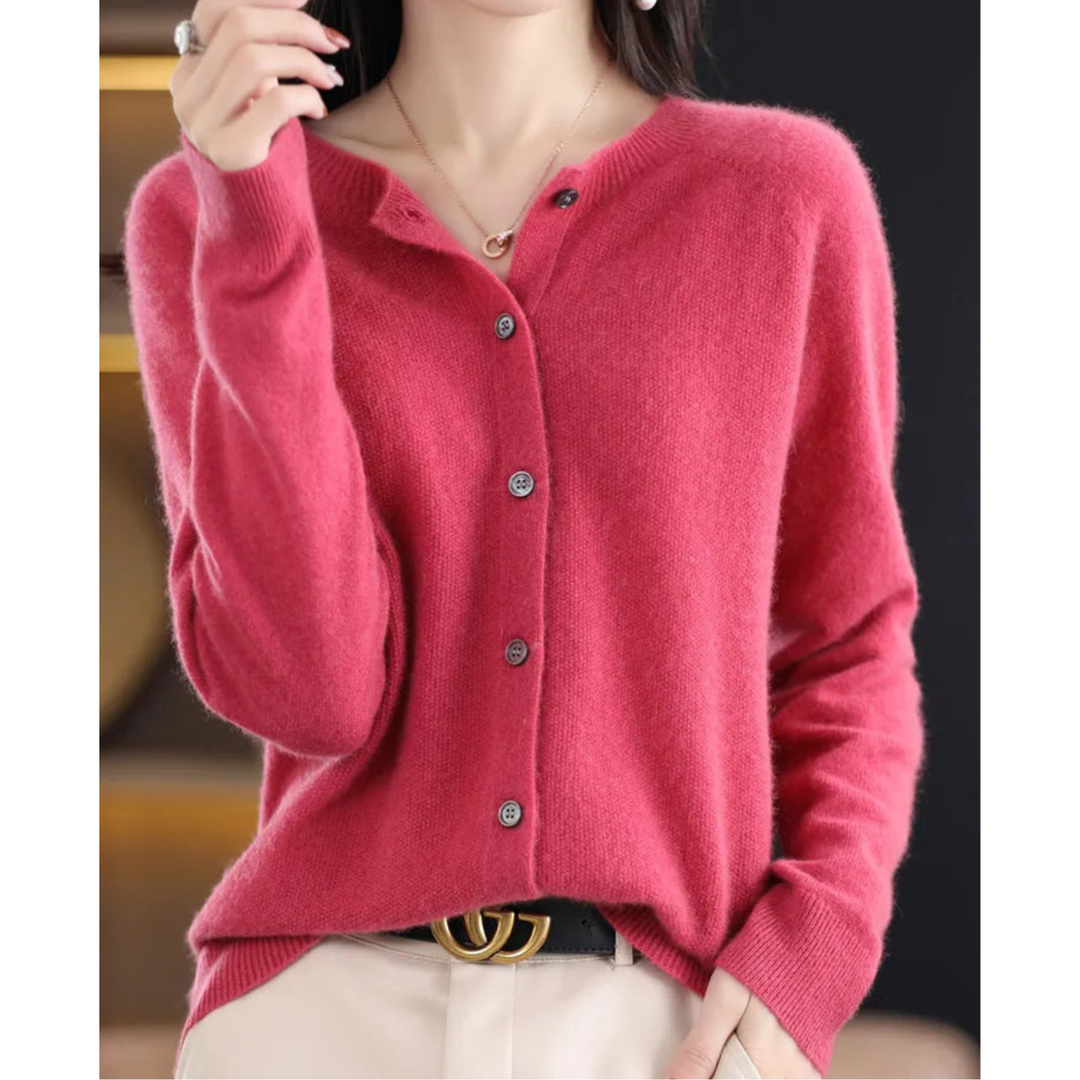 Cardigan rose framboise boutonné à col rond, porté par une femme avec un pantalon beige et une ceinture noire. 1