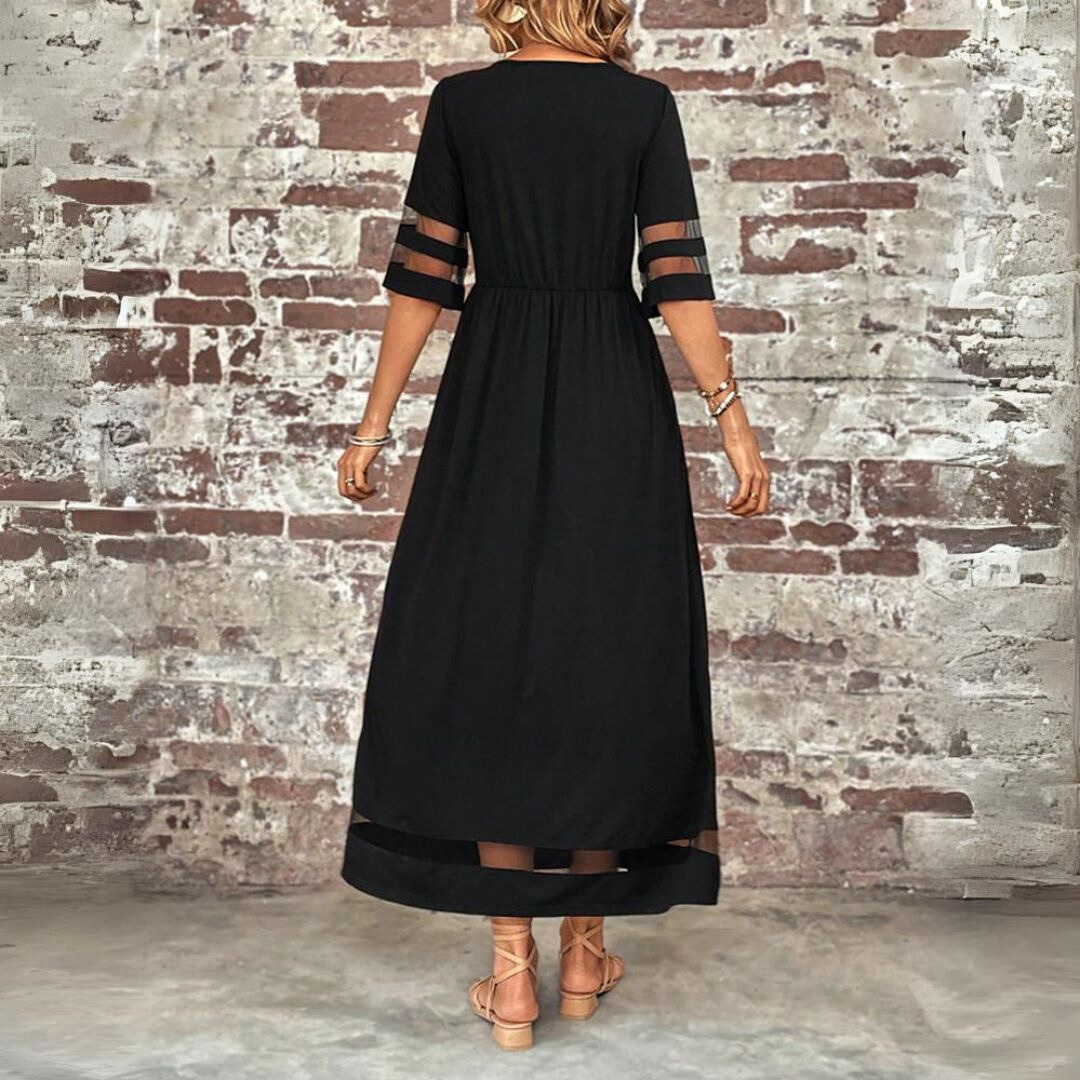 Robe longue noire vue de dos, taille froncée, manches à bandes transparentes et ourlet ajouré, portée avec des sandales à lanières. 3