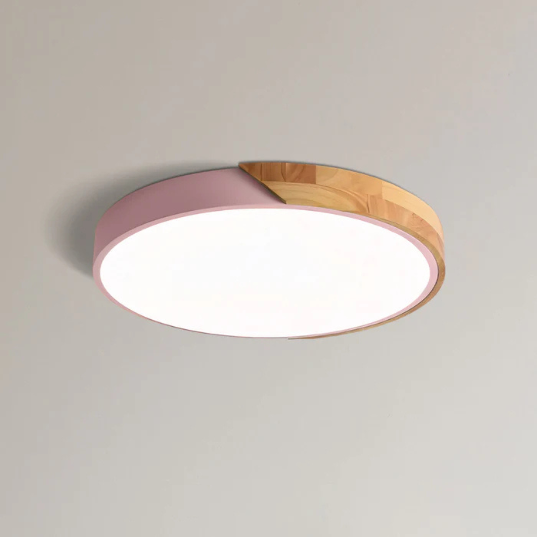 Plafonnier à coque rose et bois clair, vu de dessous sur fond uni, diffuseur allumé 11