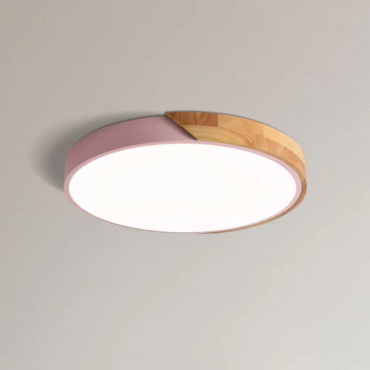 Plafonnier à coque rose et bois clair, vu de dessous sur fond uni, diffuseur allumé 11