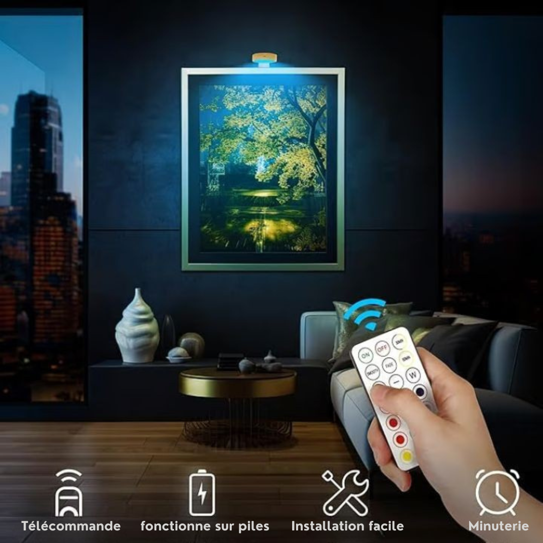 Main tenant la télécommande pour éclairer en bleu un tableau de forêt dans un salon sombre 5