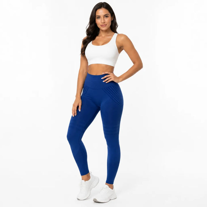 Legging bleu roi taille haute porté de face par une femme souriante en brassière blanche, main sur la hanche. 26