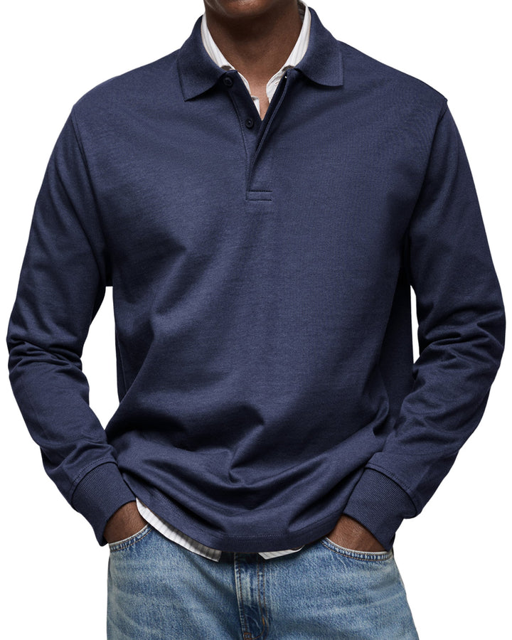 Polo à manches longues bleu marine porté par un homme, mains dans les poches, avec chemise rayée en dessous et jean. 3