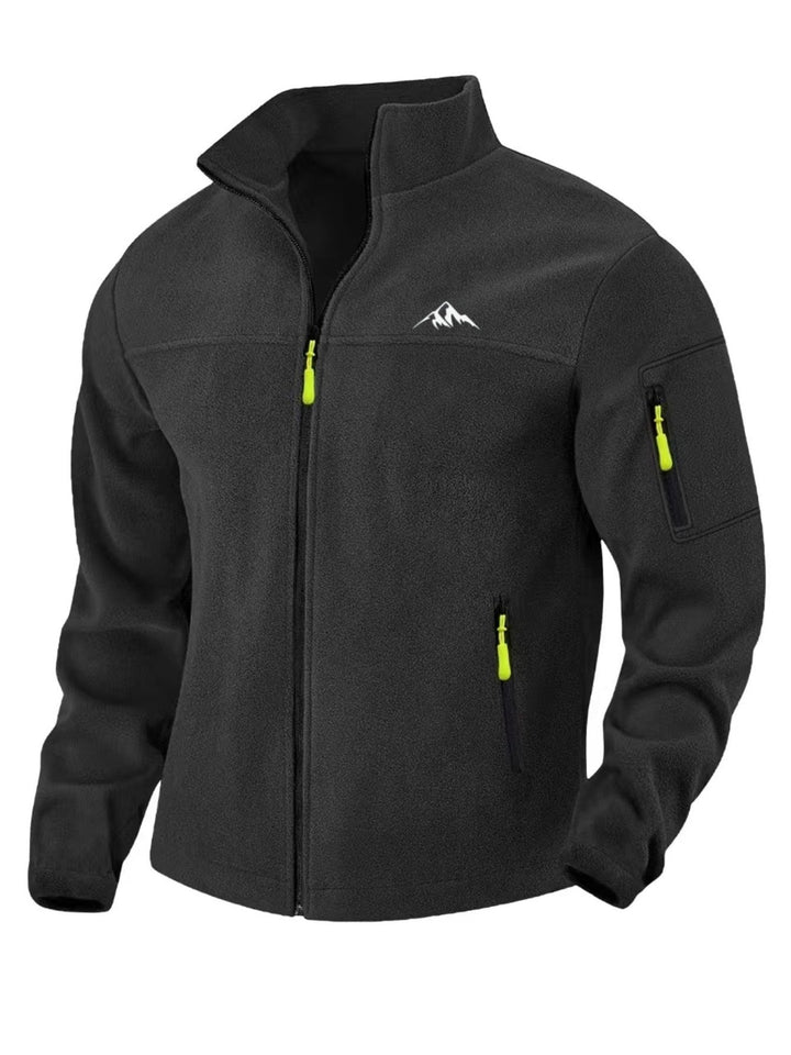 Veste polaire noire vue de face, avec tirettes de zip jaune fluo, poche zippée sur la manche et motif montagne blanc. 6