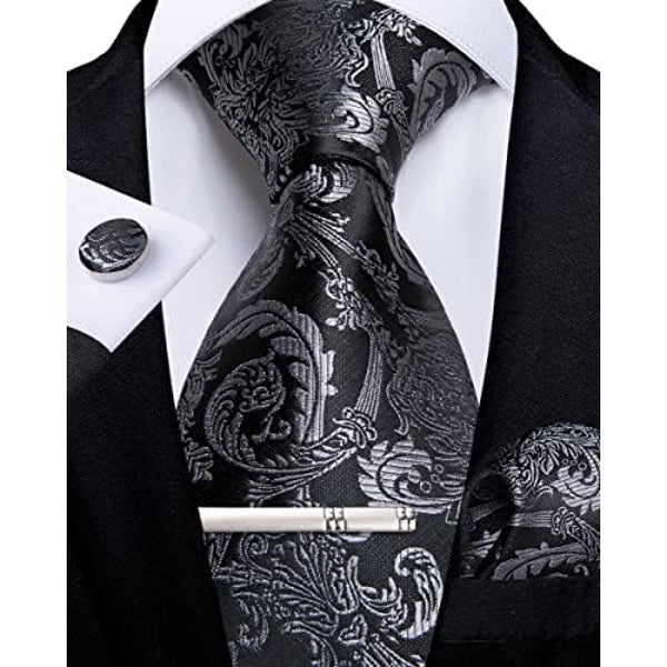 Cravate cachemire noire et gris argenté, avec pince, bouton de manchette et pochette assortis, portée sur chemise blanche et veste noire. 1