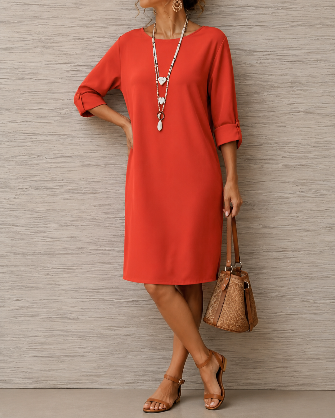 Robe rouge à manches retroussées boutonnées, portée la main sur la hanche avec un sac seau marron 4