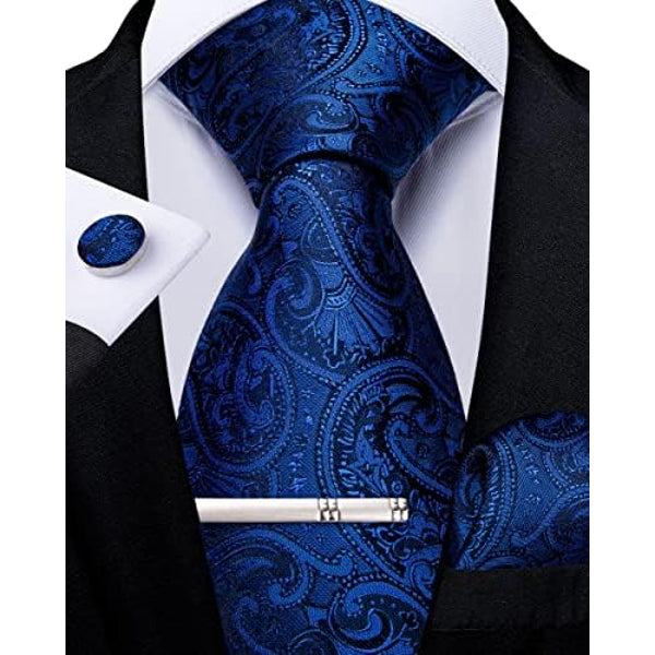 Cravate cachemire bleu roi et bleu nuit, avec pince argentée, bouton de manchette et pochette assortis, portée sous une veste noire. 10