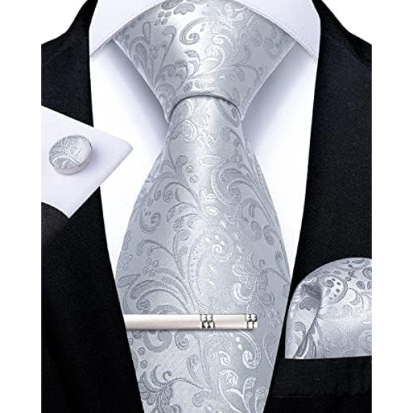 Cravate argentée à motif cachemire et floral ton sur ton, avec pince, bouton de manchette et pochette assortis, sur chemise blanche. 11