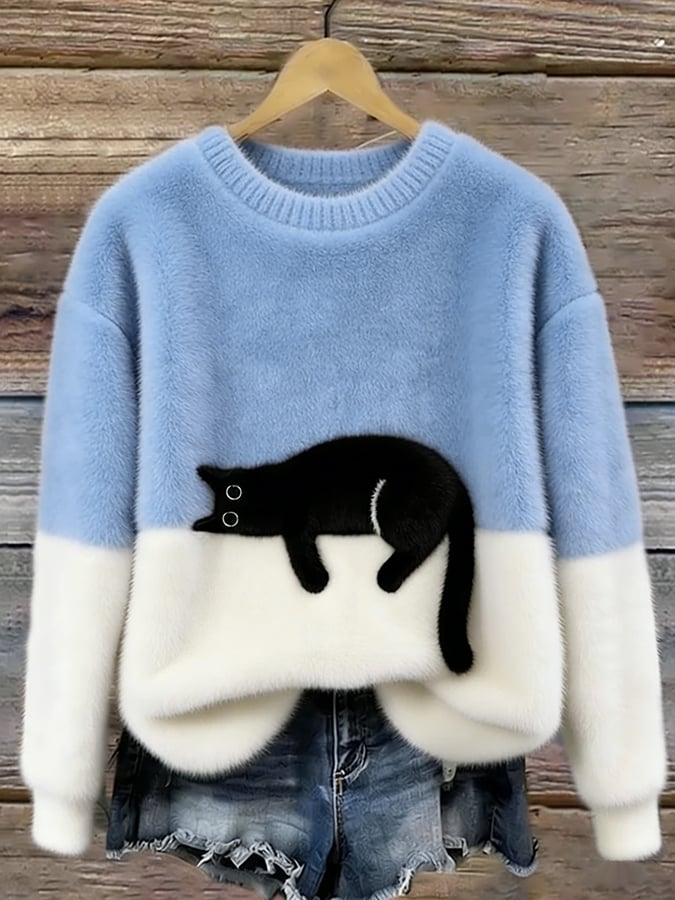 Pull bleu clair et blanc à col rond avec un chat noir allongé, présenté sur un cintre contre un mur en bois. 2