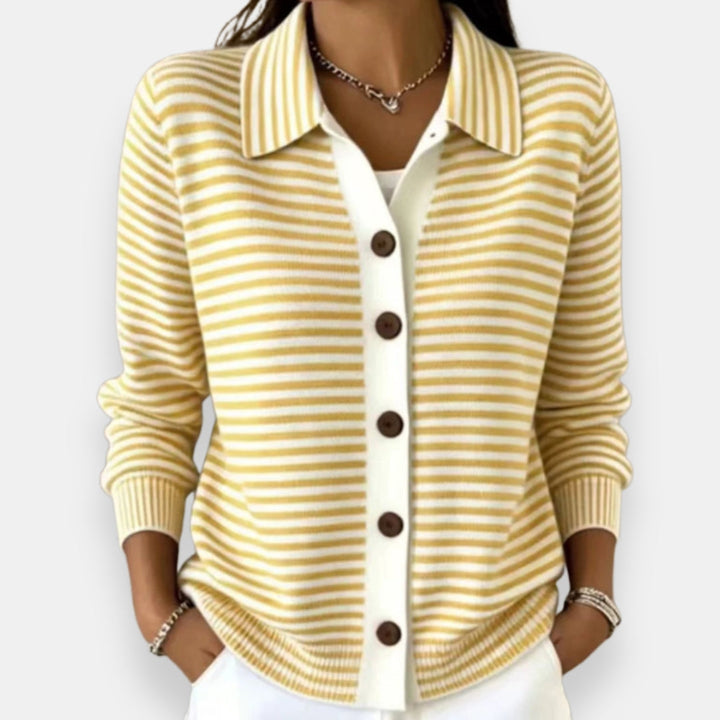 Gilet à rayures jaune pâle et blanches porté par une femme, col chemise, boutons marron, poignets côtelés, collier fin. 6