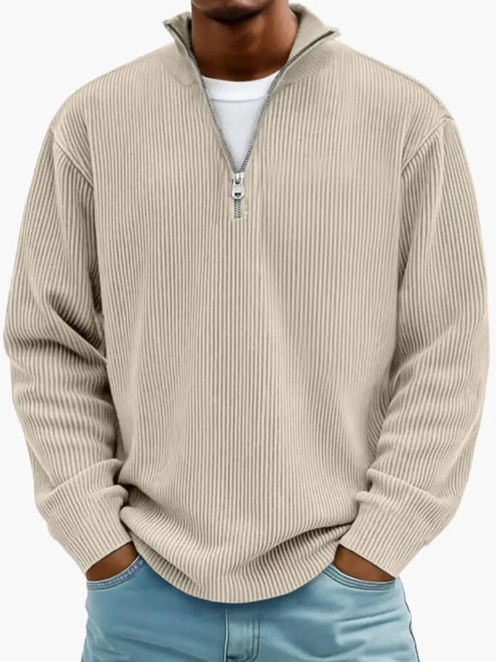 Homme portant le pull côtelé à col zippé en beige sable, mains dans les poches d'un jean bleu clair. 4