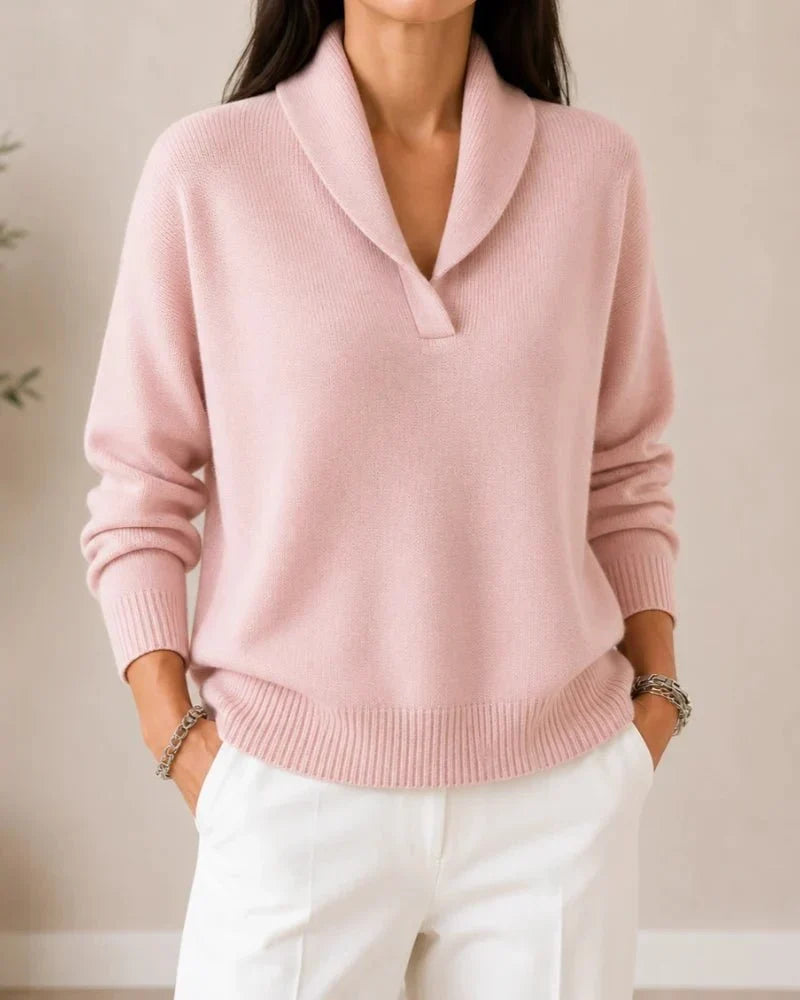 Pull porté de face en coloris rose pâle, avec pantalon blanc, col châle et bas côtelé. 12