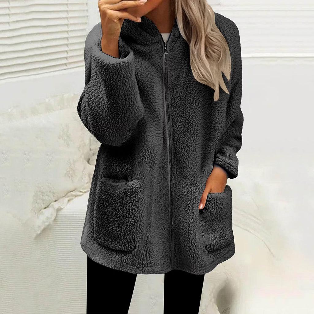 Femme portant la veste polaire douillette gris anthracite zippée, une main dans la poche, sur fond clair 1