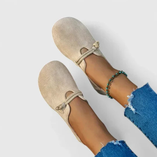 Vue de dessus de mocassins beiges à bout rond et cordon torsadé, portés avec un jean 1