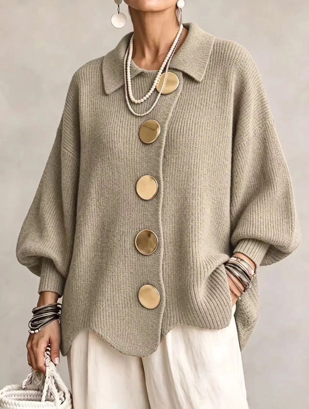 Cardigan vert sauge en maille côtelée à gros boutons dorés, porté avec un pantalon blanc et un sac tressé. 17