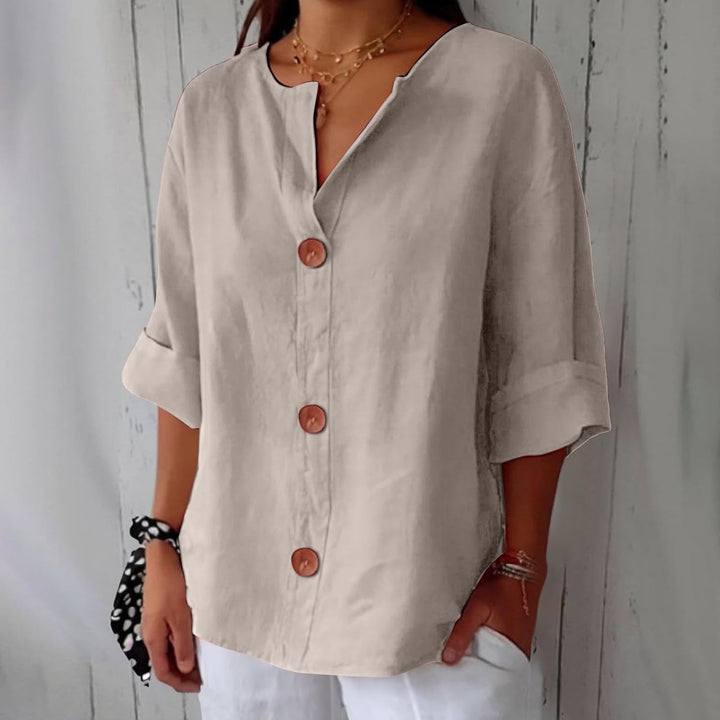 Même blouse en beige clair, portée par une mannequin, avec col en V échancré, boutons en bois marron et poignets retroussés. 3