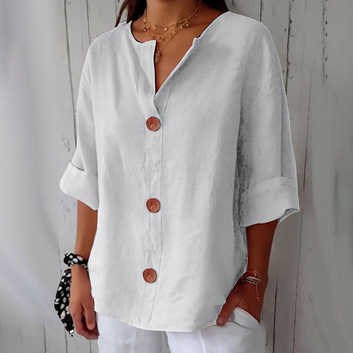 Même blouse blanche, portée avec un pantalon blanc et un chouchou à pois, boutons en bois et manches trois-quarts. 9