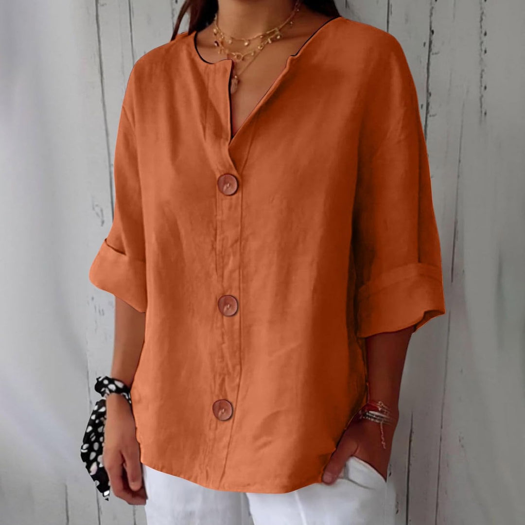 Même blouse en orange terracotta, portée avec un pantalon blanc, col en V échancré et trois boutons en bois. 7