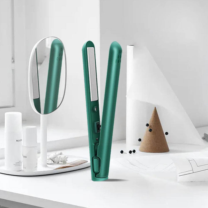 Lisseur vert ouvert posé sur une coiffeuse blanche, à côté d'un miroir ovale, de flacons et d'un cône décoratif. 2