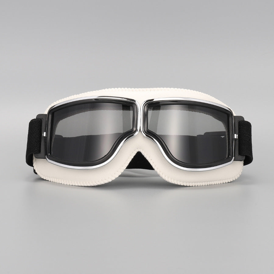 Lunettes à contour blanc crème avec verres fumés gris, monture chromée et sangle élastique noire, sur fond gris. 14