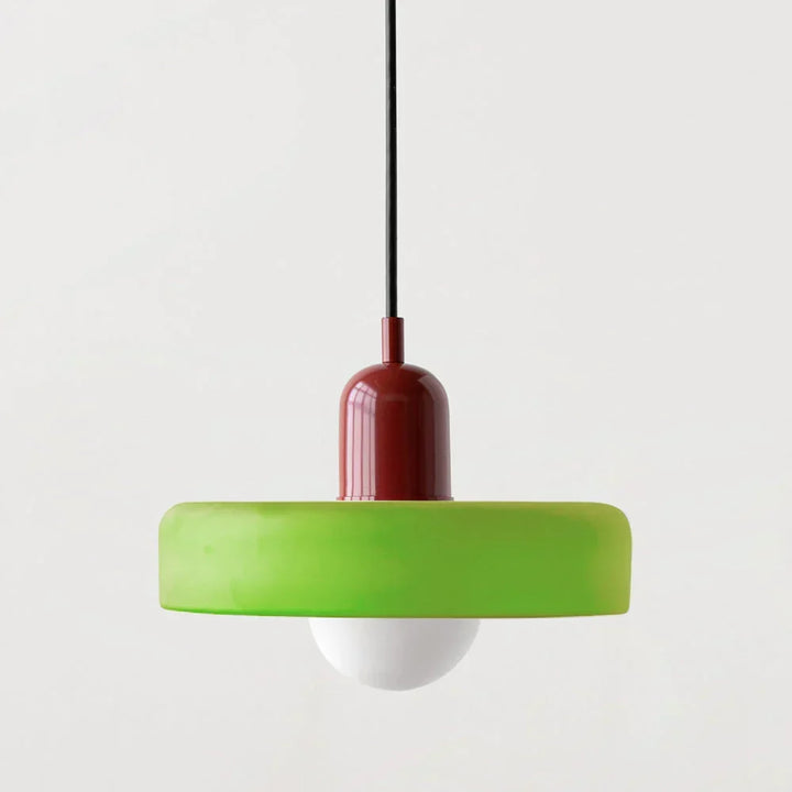 Suspension à abat-jour vert pomme en forme de disque, capuchon bordeaux brillant et globe blanc, sur fond neutre. 1