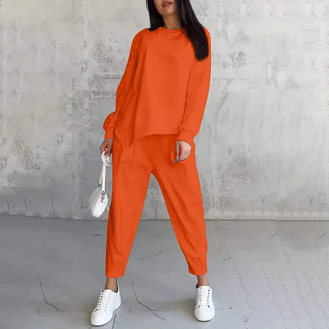 Ensemble en version orange vif, porté avec baskets blanches et petit sac blanc, bras le long du corps. 5