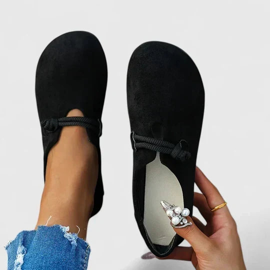 Mocassins noirs vus de dessus, l'un porté et l'autre tenu à la main montrant l'intérieur clair 4