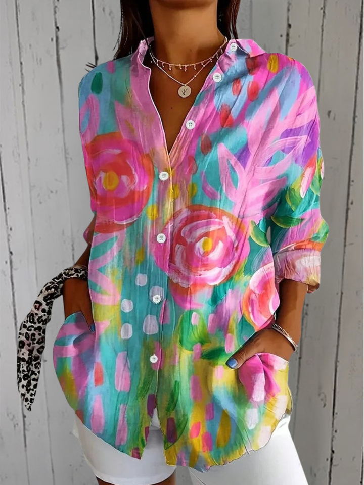 Blouse boutonnée portée avec un short blanc, motif de grandes roses peintes roses et orange sur fond turquoise et jaune. 1