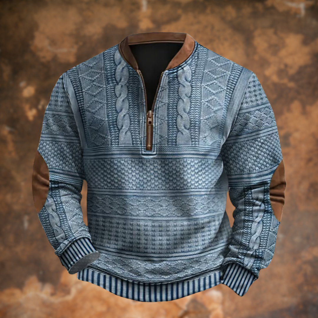 Pull demi-zip bleu-gris à motifs de torsades et losanges, col et coudières marron, vu de face sur fond rouille. 1