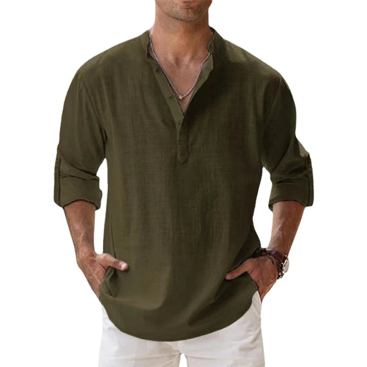 Homme portant la chemise Henley vert kaki, manches retroussées, mains dans les poches d'un pantalon blanc, vue de face. 8
