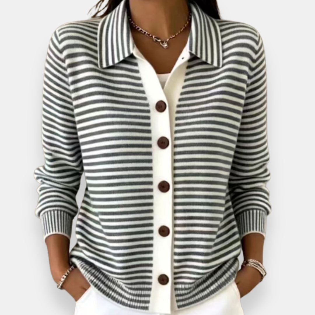 Gilet à rayures grises et blanches porté par une femme, col chemise, boutons marron, poignets côtelés, pantalon blanc. 3