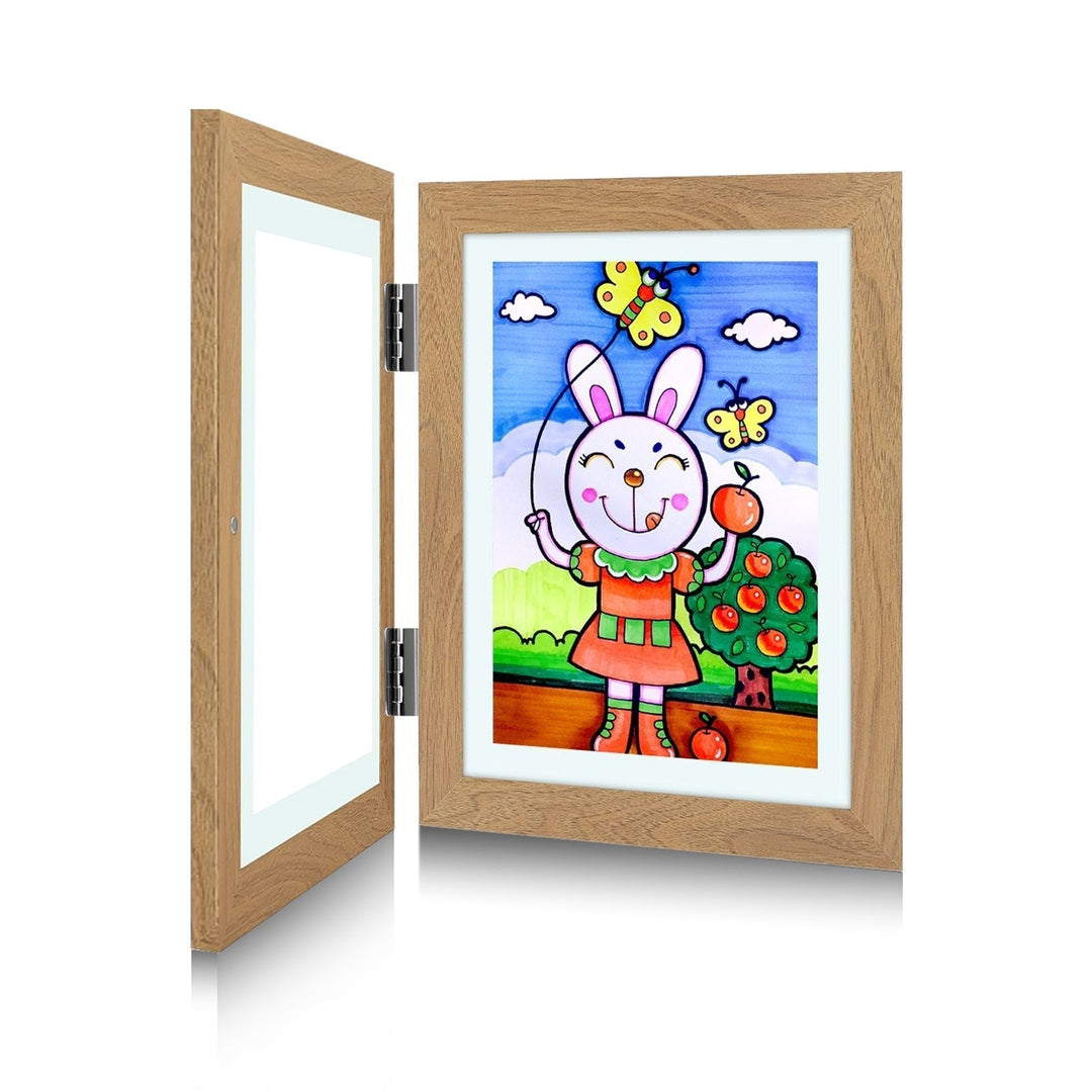 Cadre bois clair ouvert comme un livre, charnières argentées apparentes, dessin d'un lapin tenant une pomme et un cerf-volant. 6