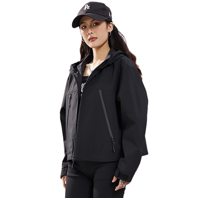 Mannequin en veste noire de trois quarts, regard vers l'objectif, fermeture éclair ouverte et poche zippée inclinée visible. 16