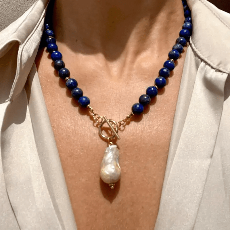 Collier porté sur un chemisier clair, grosse perle baroque nacrée au centre du décolleté 4