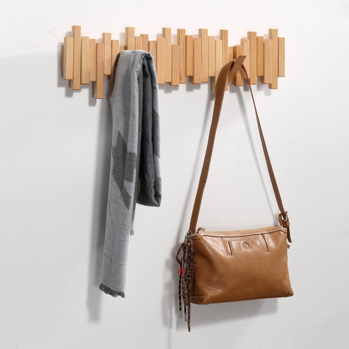 Portemanteau long en bois clair avec une écharpe grise et un sac à main marron suspendus 7