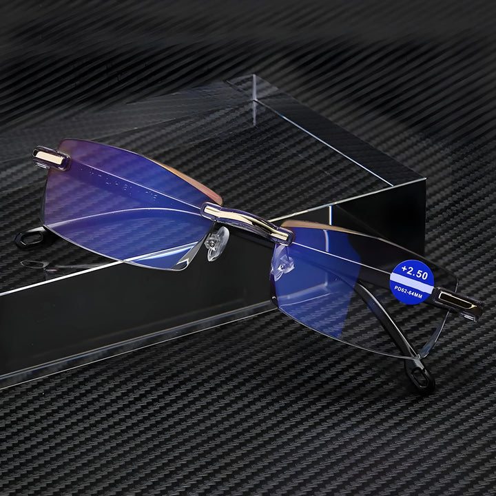 Lunettes sans monture aux reflets bleus posées contre un bloc transparent sur fond en fibre de carbone, avec une pastille de degré. 5