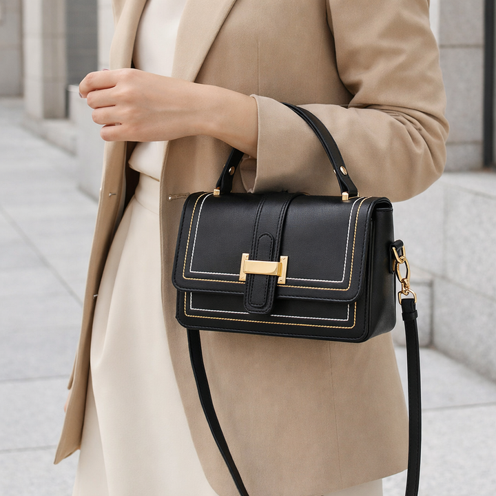 Sac noir porté à la saignée du bras par une femme en blazer beige et jupe crème. 6