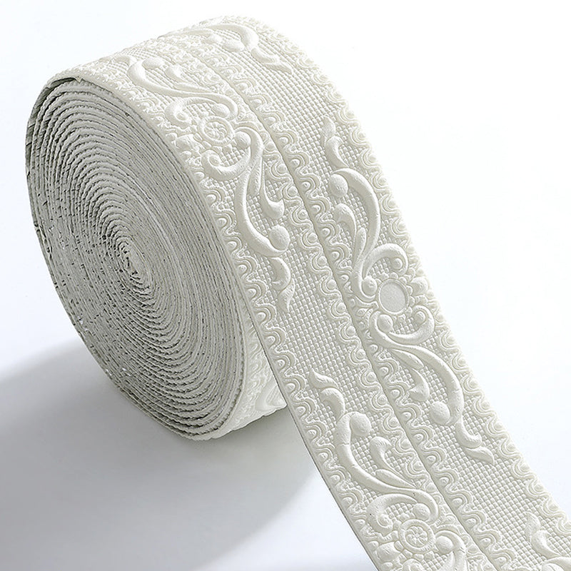 Rouleau de bordure blanche en relief, motifs floraux et volutes sur fond quadrillé, posé sur fond clair. 1