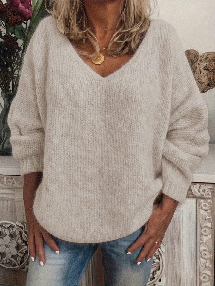 Pull beige clair à col en V à l'aspect duveteux, porté décontracté avec un jean et un collier doré. 4