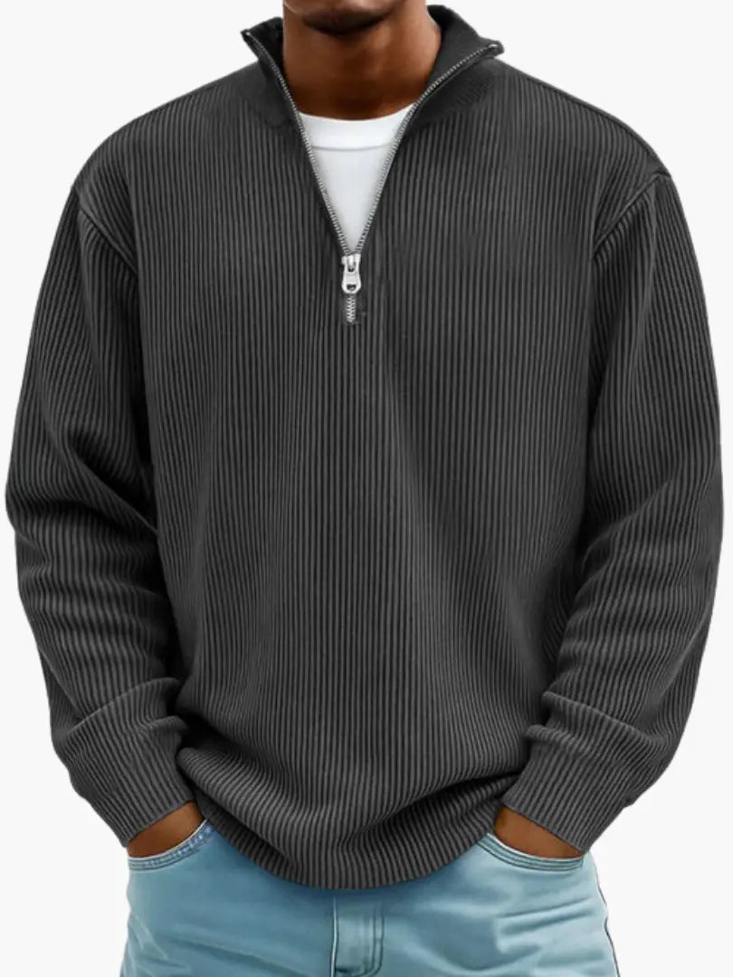 Homme portant le pull côtelé à col zippé en gris anthracite, avec un t-shirt blanc dessous et un jean bleu clair. 7