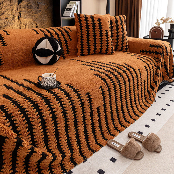 Canapé avec housse orange rouille à rayures noires en zigzag, coussins assortis et tasse décorative 12