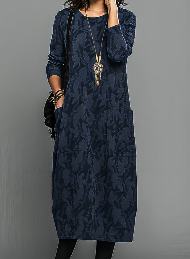 Robe portée par un modèle en bleu marine, avec long collier à pendentif et sac noir 3
