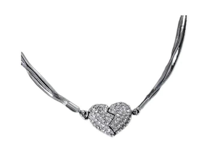 Le collier posé sur fond blanc, avec ses fines chaînes argentées multiples et son cœur en strass brisé en deux moitiés aimantées. 4