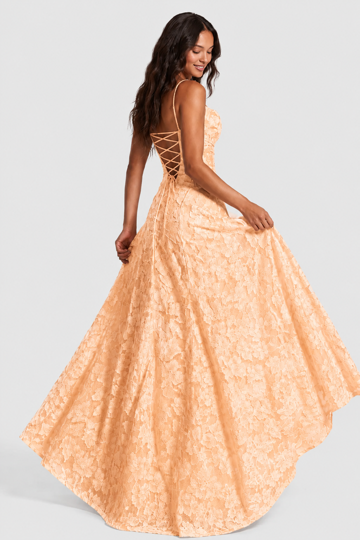 Robe pêche en dentelle florale vue de dos, laçage croisé sur le dos nu, mannequin en mouvement tenant sa jupe ample. 15