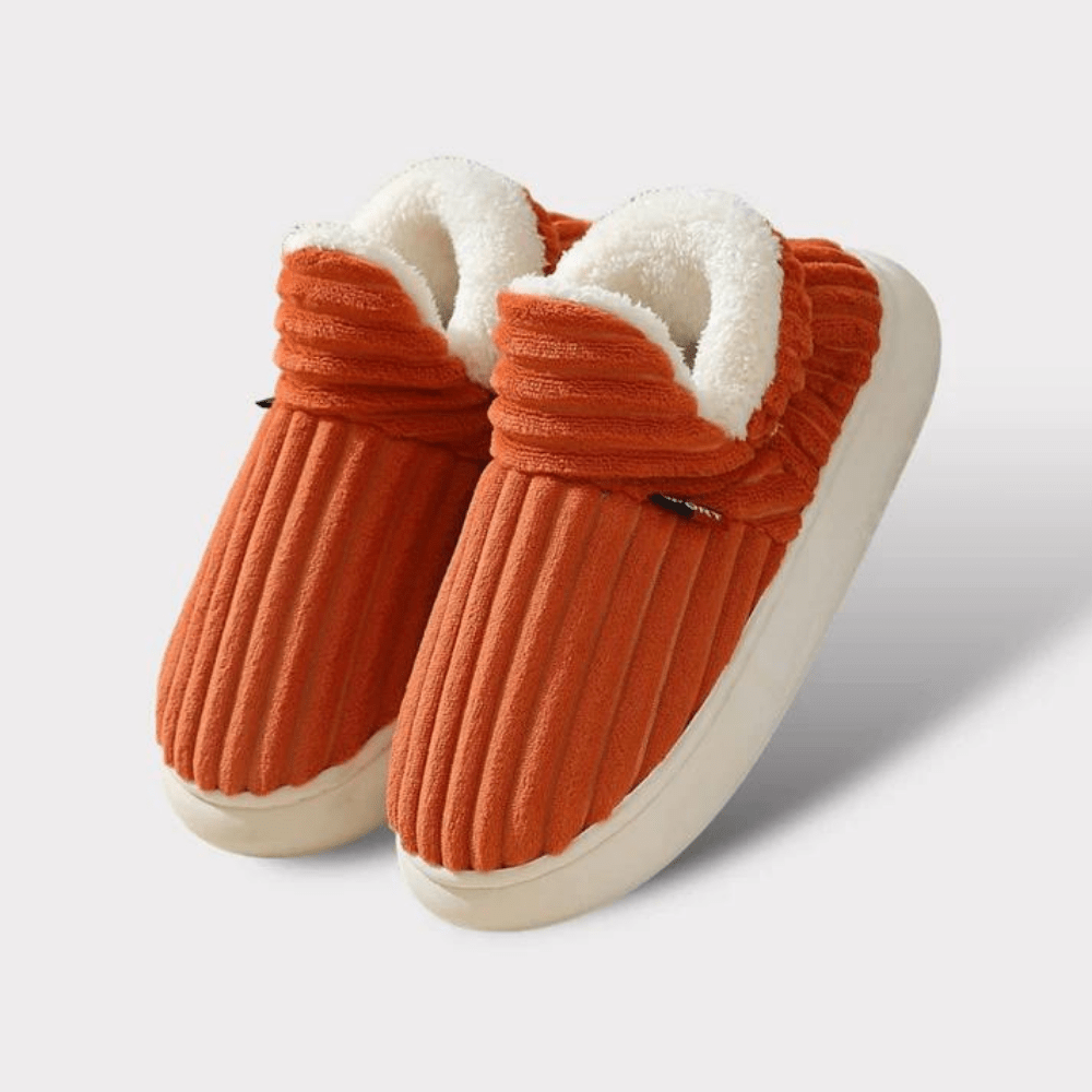 Paire de chaussons orange côtelés avec bord en peluche blanche et semelle crème, présentée sur fond clair. 18