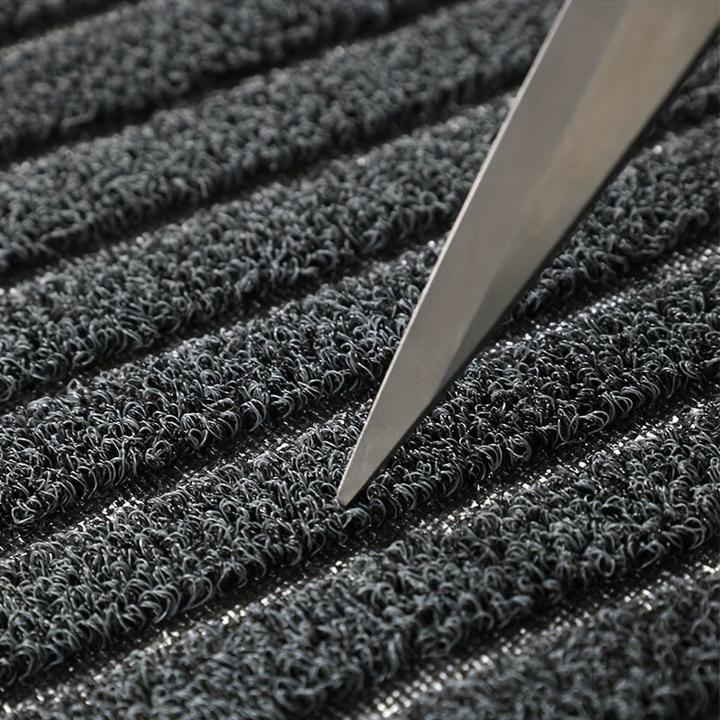 Détail des boucles de fibres du tapis, avec la pointe d'une lame de ciseaux posée entre deux bandes pour montrer leur épaisseur. 5