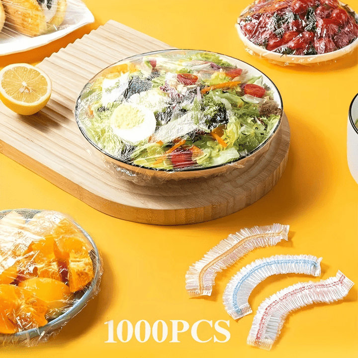 Salade composée sous un couvercle transparent sur une planche en bois, avec trois couvercles à fine bande colorée au premier plan. 9