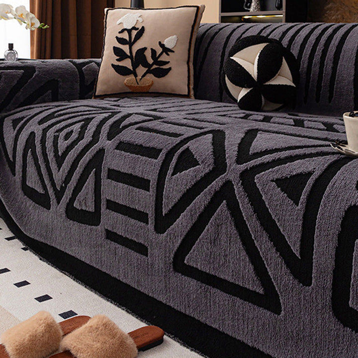 Housse gris foncé à motifs géométriques noirs, coussin à fleur brodée et chaussons au premier plan 16