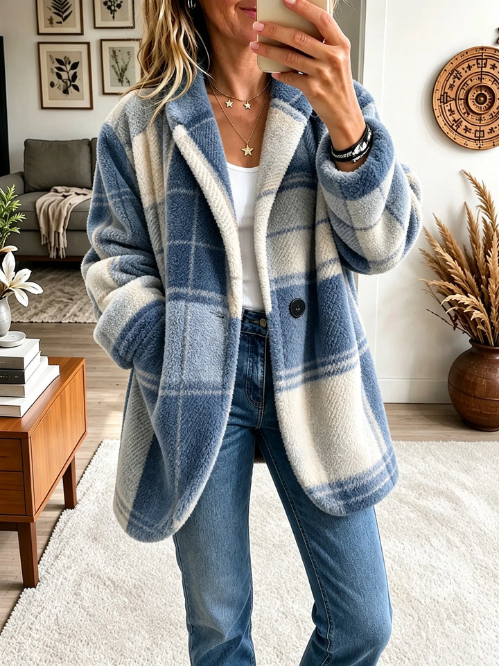 Manteau à carreaux bleu et crème en matière bouclée très douce, porté ouvert avec un jean et un haut blanc. 8