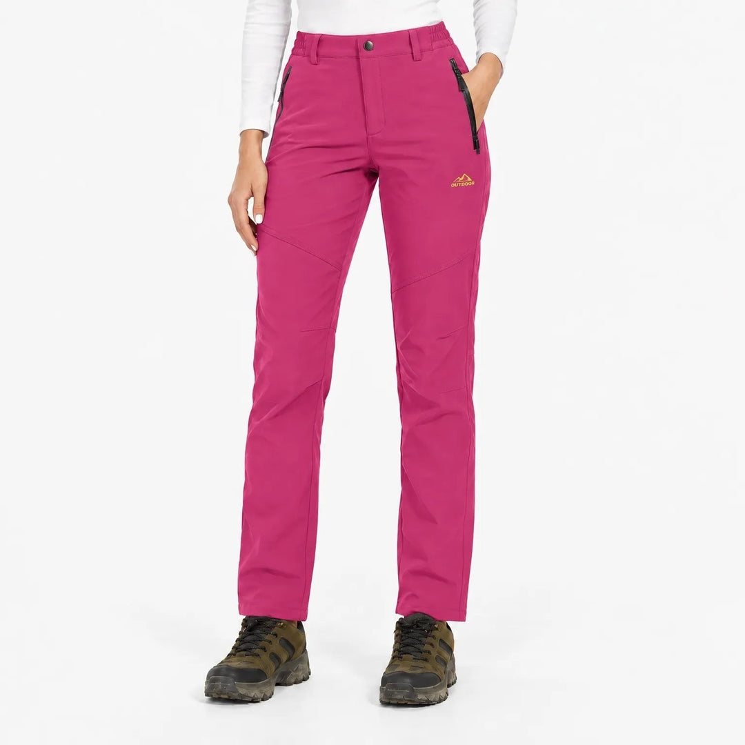 Pantalon rose fuchsia porté de face par une mannequin avec chaussures de randonnée 6